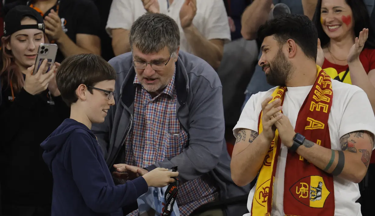 Seorang suporter cilik AS Roma memegang medali yang diberikan Jose Mourinho setelah pertandingan final Liga Europa 2022/2023 yang berlangsung di Stadion Puskas Arena, Hungaria, Jumat (01/06/2023) dini hari WIB. (AFP/Odd Andersen)