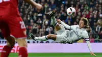 Aksi gelandang Real Madrid, Luca Modric menendang bola saat berhadapan dengan Sevilla pada pertandingan pertama babak 16 besar Copa del Rey di Santiago Bernabeu, Spanyol (5/1). Madrid menang atas Sevilla 3-0. (AFP Photo/Gerard Julien)