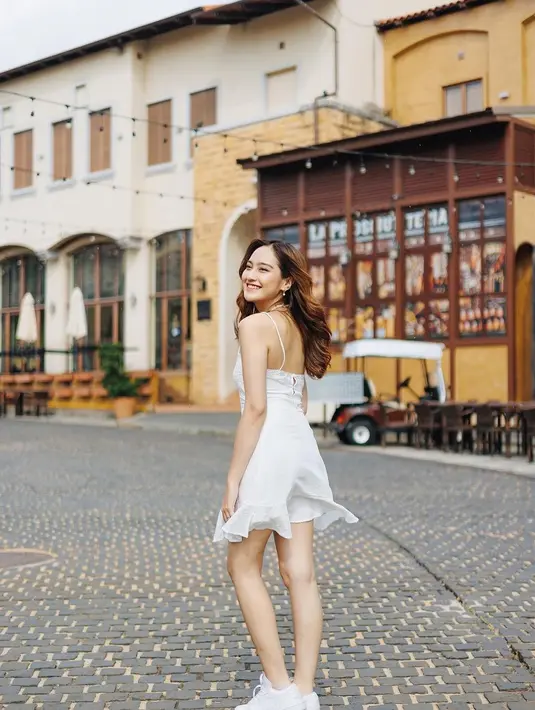 Penampilan manis nan sederhana Salshabilla Adriani pakai strappy mini dress berwarna putih polos yang dipadunya dengan sneakers yang juga berwarna putih. [Foto: Instagram/salshabillaadr]