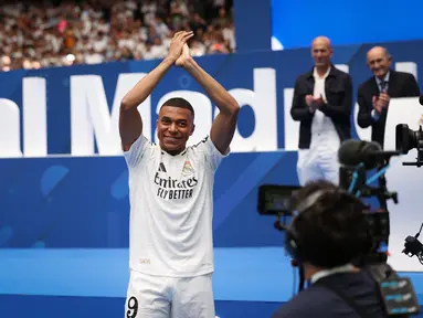 Penyerang Prancis Kylian Mbappe menyapa para penggemar saat penampilan pertamanya sebagai pemain Real Madrid di Estadio Santiago Bernabeu, Selasa (16/7/2024). (Pierre-Philippe MARCOU / AFP)