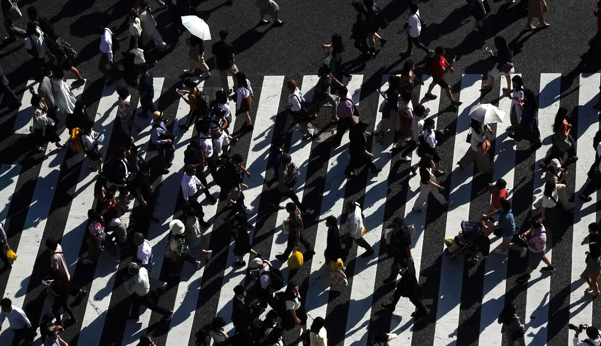 Pejalan kaki berjalan melintasi Shibuya Crossing yang juga disebut sebagai persimpangan pejalan kaki tersibuk dunia, di Tokyo, 13 Juni 2019. Di Shibuya Crossing ini juga dijadikan lokasi syuting dari film Fast & Farious: Tokyo Drift. (AP Photo/Jae C. Hong)