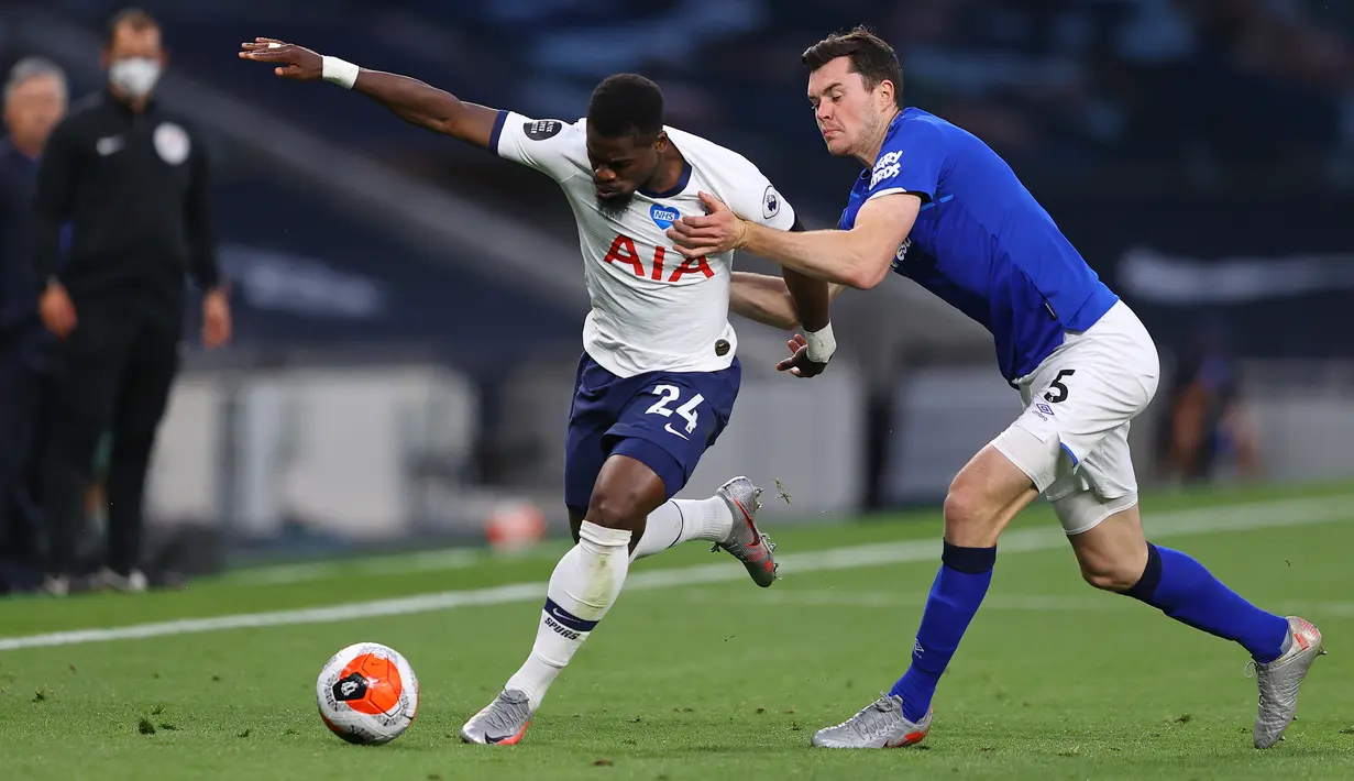 Bek Everton, Michael Keane berebut bola dengan bek Tottenham Hotspur, Serge Aurier pada lanjutan pertandingan Liga Inggris di Tottenham Stadium, Selasa (7/7/2020) dini hari. Tottenham Hotspur susah payah mengalahkan Everton 1-0. (Richard Heathcote/POOL/AFP)