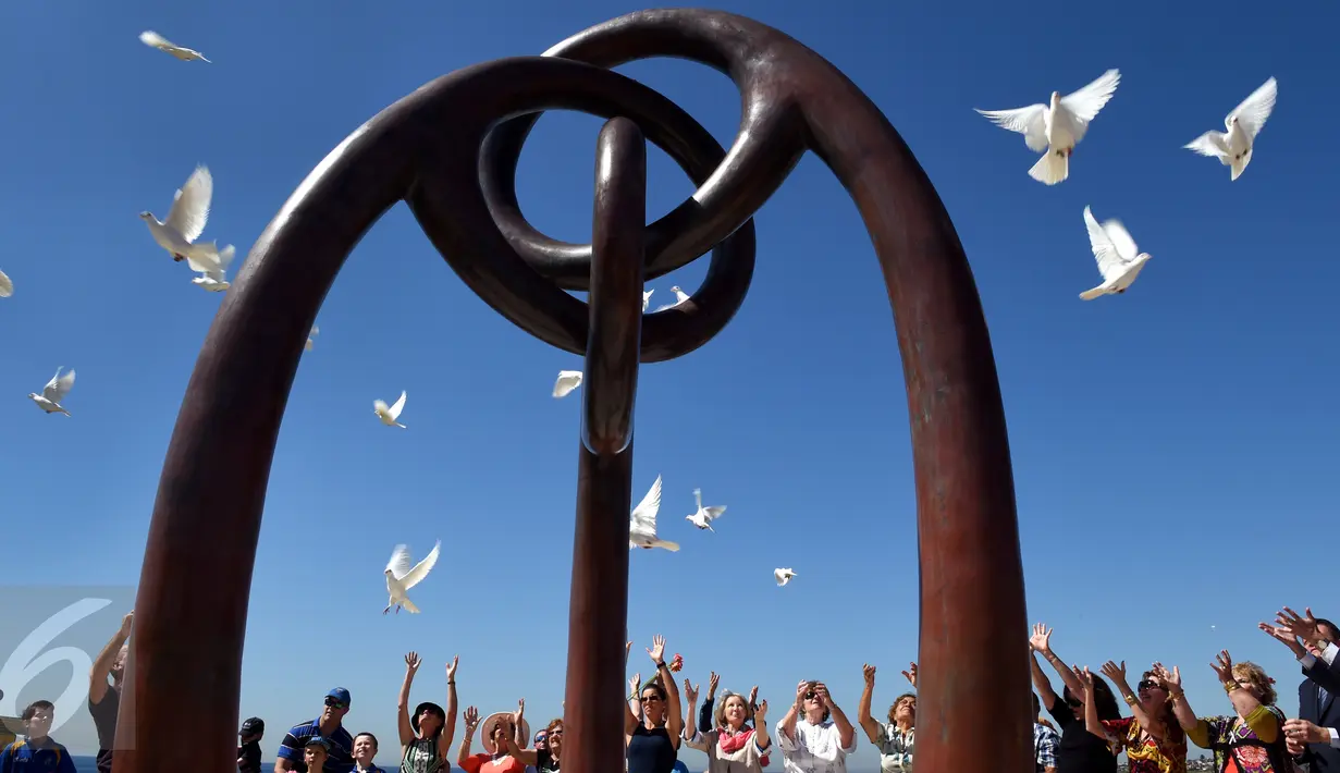 Australia memperingati tragedi Bom Bali I di Sydney Coogee Beach, Sydney, Senin (12/10/2015). Dalam peringatan tersebut, warga melepaskan 88 merpati dan meletakkan karangan bunga untuk mengenang para korban. (AFP/William West)