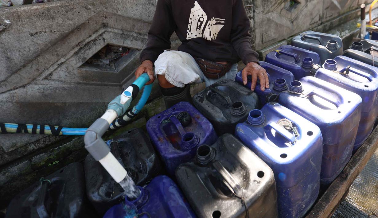 Pedagang mengisi jeriken dengan air bersih untuk segera didistribusikan kepada pelanggan di Kawasan Muara Angke, Jakarta, Kamis (28/5/2026). (Kapanlagi.com/Budy Santoso)