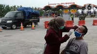 Petugas medis melakukan tes COVID-19 terhadap seorang pria di Gerbang Tol Palimanan, Jakarta, Jumat, (7/5/2021). Gerbang Tol Palimanan sepi karena adanya kebijakan larangan mudik Lebaran pada tanggal 6-17 Mei 2021 untuk memutus penyebaran COVID-19. (merdeka.com/Imam Buhori)