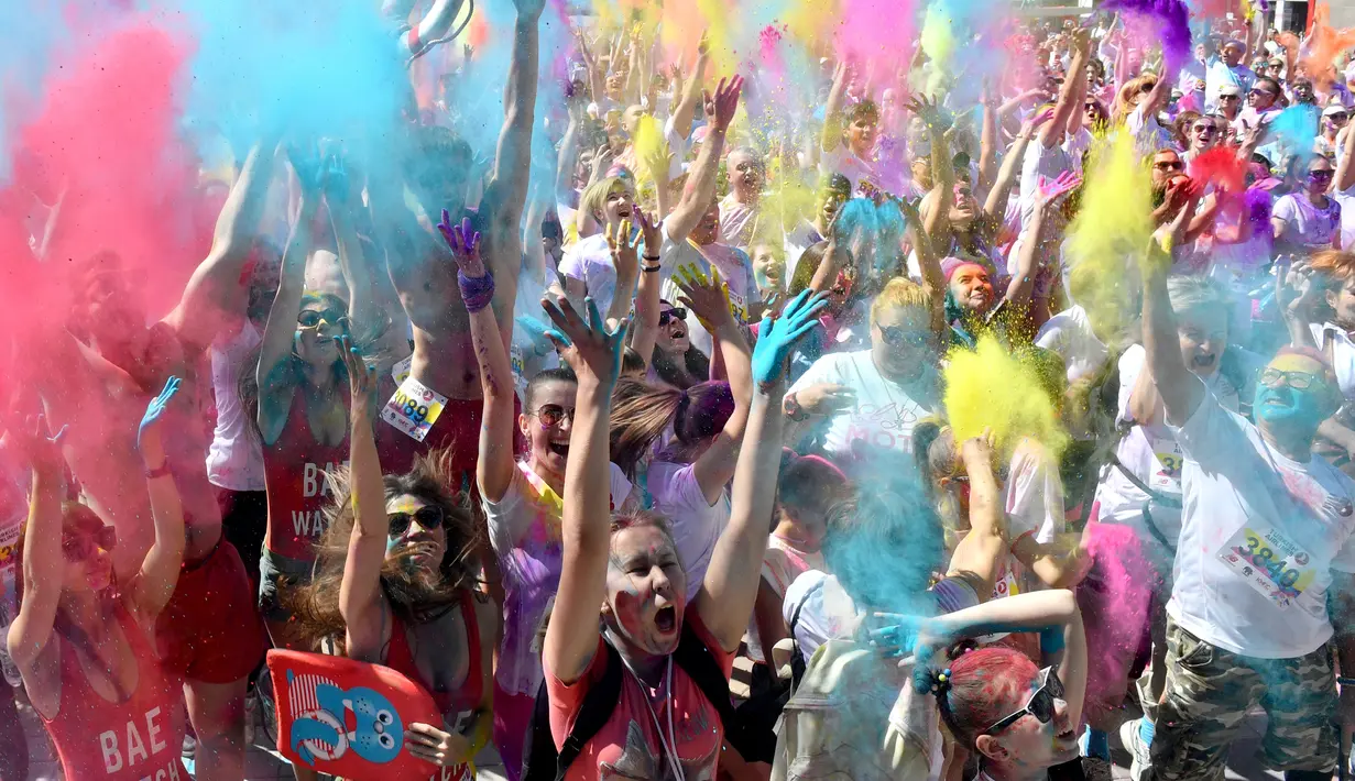 Peserta lomba bergembira saat disiram bubuk warna-warni saat mengikuti Kyiv Color Run di Kiev, Ukraina, Minggu (10/6). The Color Run diluncurkan dan diselenggarakan pertama kali pada Januari 2012 di Amerika Serikat. (AFP PHOTO/Sergei SUPINSKY)