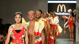 Model berjalan di atas runaway memperagakan koleksi yang diberi nama McDCouture Collection di Miami Swim Week, 20 Juni 2017. Koleksi baju renang tersebut dikreasikan dengan ribuan kemasan makanan cepat saji McDonald's. (ALEXANDER TAMARGO/GETTY IMAGES/AFP)