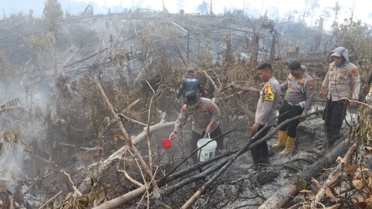 Polisi di Indragiri Hulu berusaha mendinginkan kebakaran lahan yang bisa memicu kabut asap Riau.