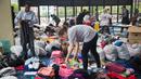 Seorang relawan memilah baju hasil donasi sebelum dibagikan kepada korban Harvey di Houston, Selasa (29/8). Puluhan badan amal terpercaya lainnya turut membantu aksi penggalangan dana untuk korban Harvey. (Marie D. De Jesus/Houston Chronicle via AP)