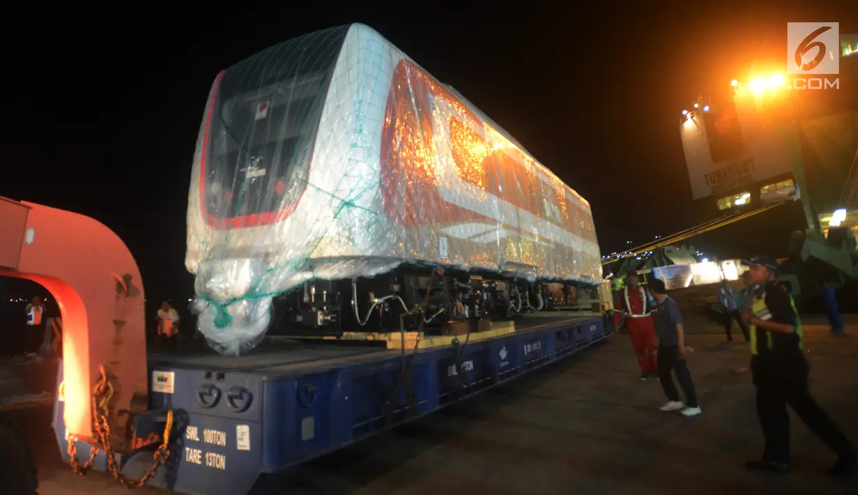 Pekerja dibantu alat berat menarik gerbong kereta ringan/Light Rail Transit (LRT) di Pelabuhan Car Terminal, Tanjung Priok, Jakarta, Jumat (13/4). Gerbong ini akan langsung diangkut menuju Dipo LRt di Kelapa Gading.  (Merdeka.com/Imam Buhori)