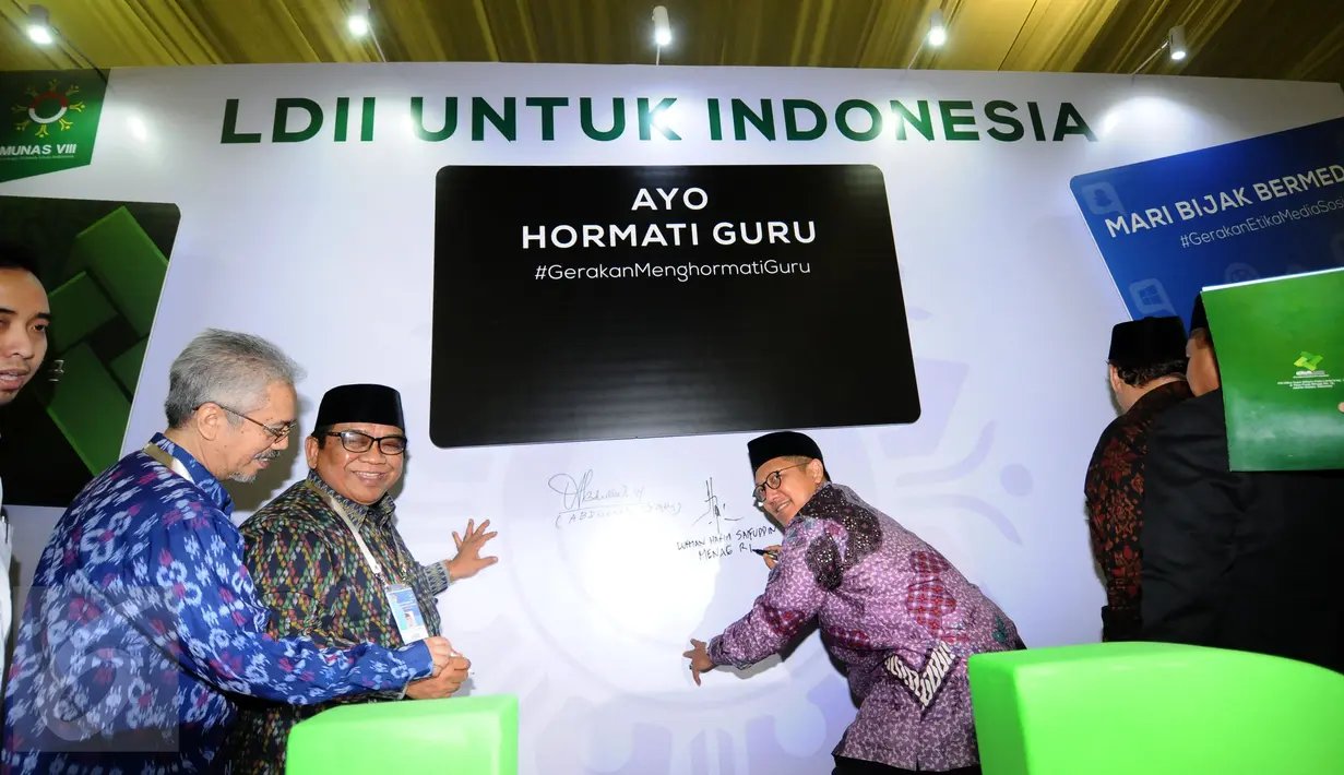 Menteri Agama Lukman Hakim Saifudin (kanan) bersama Ketua Umum DPP Lembaga Dakwah Islam Indonesia, KH. Abdullah Syam (kedua kiri) menandatangani komitmen bersama usai membuka Munas VIII LDII di Jakarta, Selasa (8/11). (Liputan6.com/Helmi Fithriansyah)