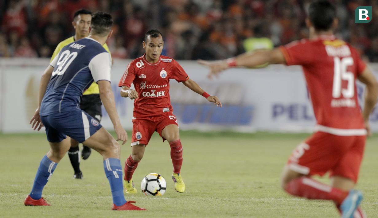 Gelandang Persija Jakarta, Riko Simanjuntak, berusaha melewati gelandang Arema FC, Ahmet Atayev, pada laga Liga 1 di SUGBK, Jakarta, Sabtu (31/3/2018). Babak pertama berakhir imbang 1-1. (Bola.com/M Iqbal Ichsan)
