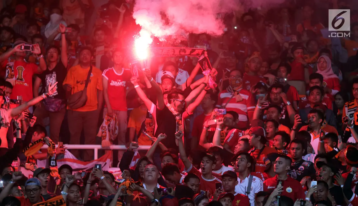 Suporter tim Macan Kemayoran menyalakan flare merayakan gelar juara Go-Jek Liga 1 Indonesia 2018 bersama Bukalapak yang diraih Persija di Stadion GBK, Jakarta, Minggu (9/12). Persija meraih gelar juara dengan 62 poin. (Liputan6.com/Helmi Fithriansyah)