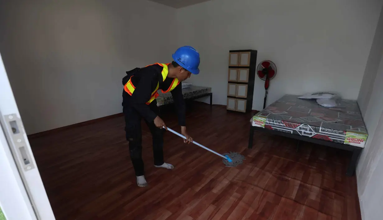 Setiap unit dilengkapi fasilitas dasar seperti kasur/tempat tidur, lemari, dan kipas angin. Tampak dalam foto, aktivitas pekerja menyelesaikan Hunian Sementara (Huntara) di kawasan Kramat Raya, Senen, Jakarta Pusat, Jumat (24/4/2026). (Kapanlagi.com/Budy Santoso)