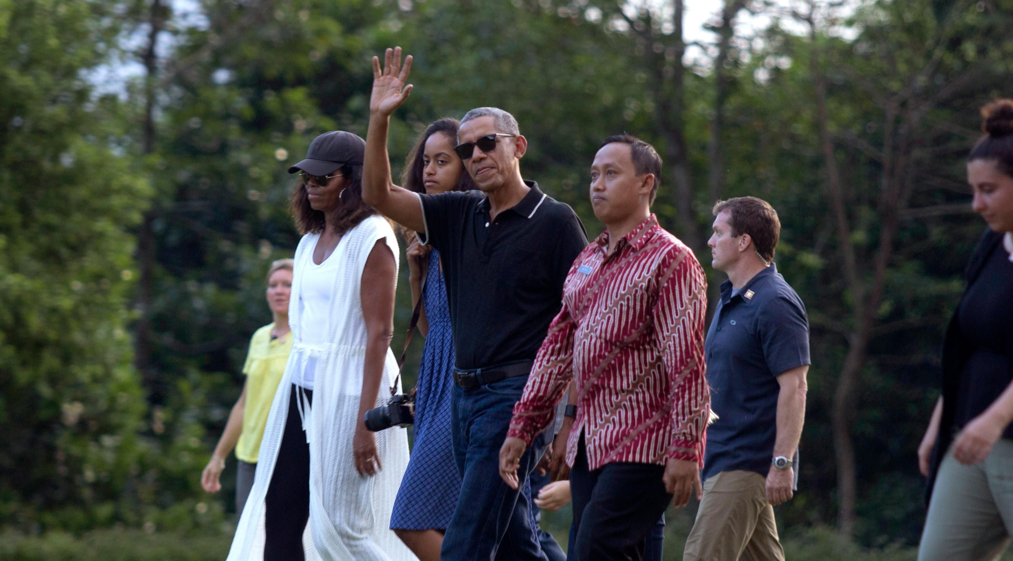 Mantan Presiden AS, Barack Obama mengabadikan gambar dari ponselnya saat berwisata di Candi Borobudur, Magelang, Jawa Tengah, Indonesia, (28/6). Obama mengenakan celana jeans biru dan polo shirt hitam. (AP Photo / Slamet Riyadi)
