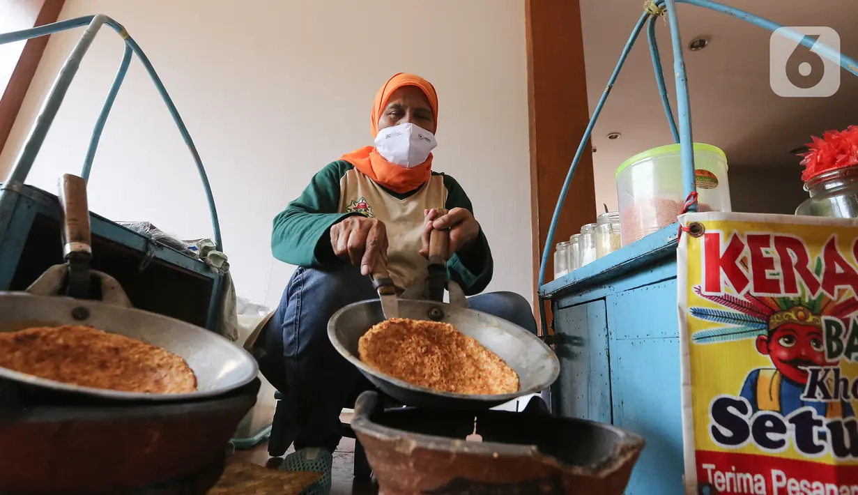 Pedagang membuat kerak telor di perkampungan Budaya Betawi, Setu Babakan, Jakarta, Sabtu (8/8/2020). Selama pandemi Covid-19 pedagang yang biasa mangkal di objek wisata tersebut sepi pembeli, namun mereka tetap bertahan untuk memenuhi kebutuhan hidup. (Liputan6.com/Fery Pradolo)