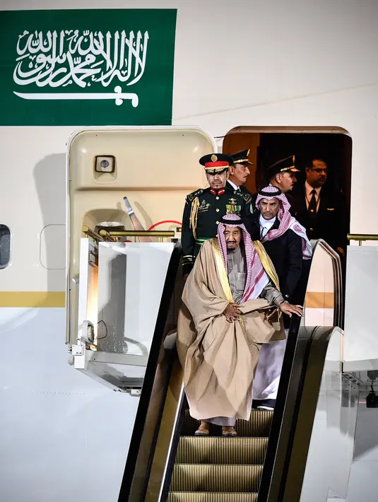 Pengawal membantu Raja Arab Saudi, Salman bin Abdulaziz Al Saud menuruni tangga eskalator saat tiba di Vnukovo International Airport, Rusia, 4 Oktober 2017. Eskalator emas milik Raja Salman macet setelah bergerak beberapa saat. (Alexander NEMENOV/AFP)