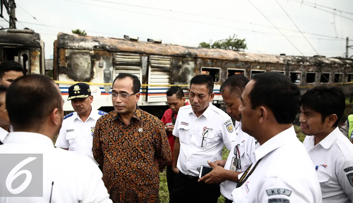Menhub Budi Karya menggali keterangan dari petugas saat meninjau lokasi terbakarnya dua gerbong kereta Kerta Jaya kelas Ekonomi di dekat Stasiun Tanjung Priok, Jakarta, Kamis (25/8). (Liputan6.com/Faizal Fanani)