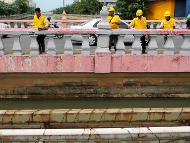 Sejumlah pekerja melakukan pengecatan Jembatan Merah di Jalan Pangeran Jayakarta, Jakarta, Selasa (27/12). Pengecatan dilakukan untuk memperindah jembatan agar terlihat bersih dan terawat. (Liputan6.com/Gempur M. Surya)