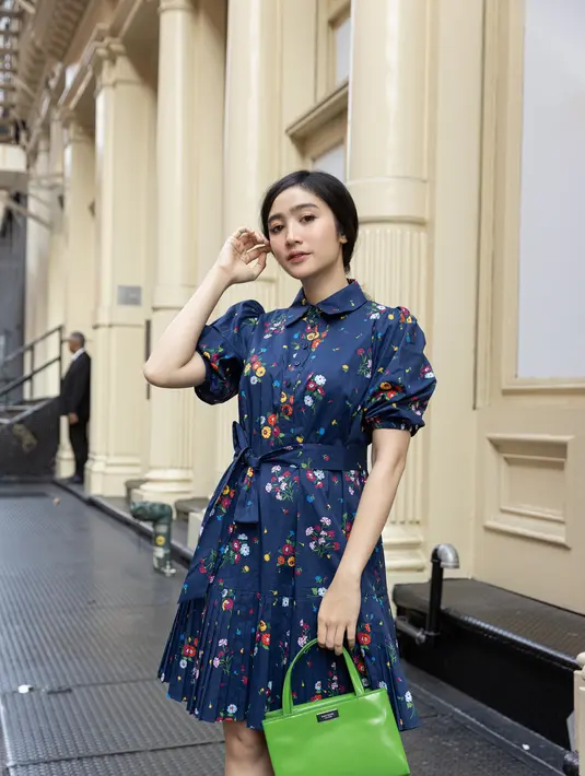 Febby terlihat vintage mengenakan bouquet toss pleated dress. Dress berwarna biru dengan motif bouquet bunga ini memiliki puff sleevess dan tali pinggang yang dapat disesuaikan, seharga Rp 6.790.000,-. Ia juga membawa sam icon mini tote bag dalam warna ikonik kate spade green seharga Rp 7.590.000,-. Kate Spade