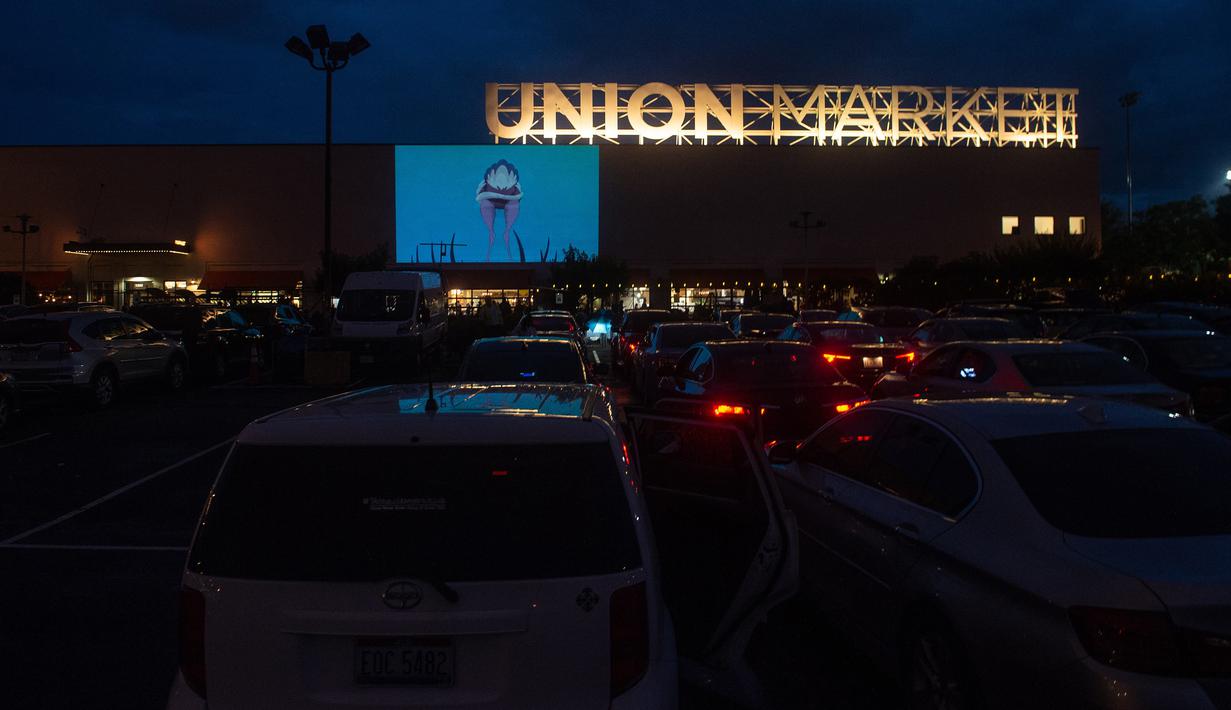 Puluhan mobil terparkir di depan layar bioskop saat pemutaran film drive-in di Union Market, Washington, 3 Agustus 2018. Kepopuleran teater-teater luar ruangan dengan layar raksasa ini mencapai puncaknya pada akhir 1950-an. (AFP PHOTO/Nicholas Kamm)