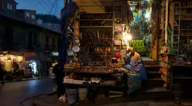 Seorang wanita duduk di toko jimat andalan penganut Pachamama di Pasar Penyihir, kota tua La Paz, Bolivia, 10 Juli 2018. Pasar bernama Mercado de las Brujas ini menjual barang-barang aneh dan segala sesuatu yang berhubungan dengan sihir. (AP/Juan Karita)