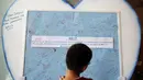 Seorang anak melihat-lihat pesan belasungkawa bagi para korban jatuhnya pesawat Malaysia Airlines MH-17 yang dipajang di Kuala Lumpur, (20/7/2014). (REUTERS/Olivia Harris)
