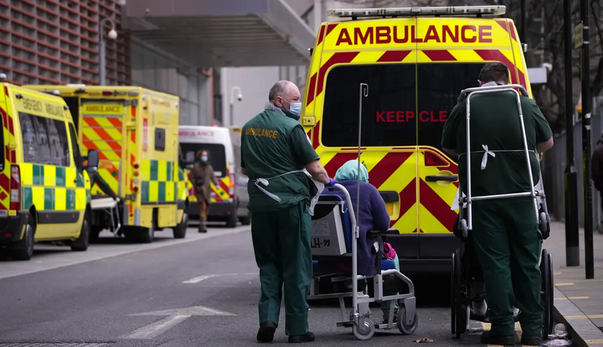 Paramedis membawa pasien dari ambulans ke Rumah Sakit Royal London, Inggris, 6 Januari 2022. Inggris memangkas waktu isolasi pasien COVID-19 dari 10 menjadi 7 hari karena kekurangan tenaga kesehatan akibat lonjakan kasus yang dipicu Omicron. (AP Photo/Matt Dunham)