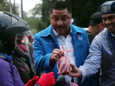 Aktifis GMKI memberikan bunga dan takjil kepada pengguna jalan saat memperingati hari lahir Pancasila,  Jakarta, Rabu (30/5). Pemberian takjil ini sebagai bentuk menjaga empat pilar kebangsaan yang digaungkan MPR RI. (Liputan6.com/Johan Tallo)