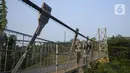 Warga melihat-lihat pemandangan dari atas jembatan gantung di Kelurahan Curug, Bojongsari, Kota Depok, Jawa Barat, Senin (24/8/2020). Setiap sore, warga sekitar bermain di jembatan tersebut sambil menikmati matahari tenggelam. (merdeka.com/Dwi Narwoko)