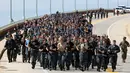 Kadet tahun pertama berlari melintasi jembatan selama Sea Trials, di Akademi Angkatan Laut AS, Annapolis Md., (16/5). Latihan ini merupakan penanda berakhirnya satu tahun pertama pendidikan militer mereka. (AP Photo/Patrick Semansky)