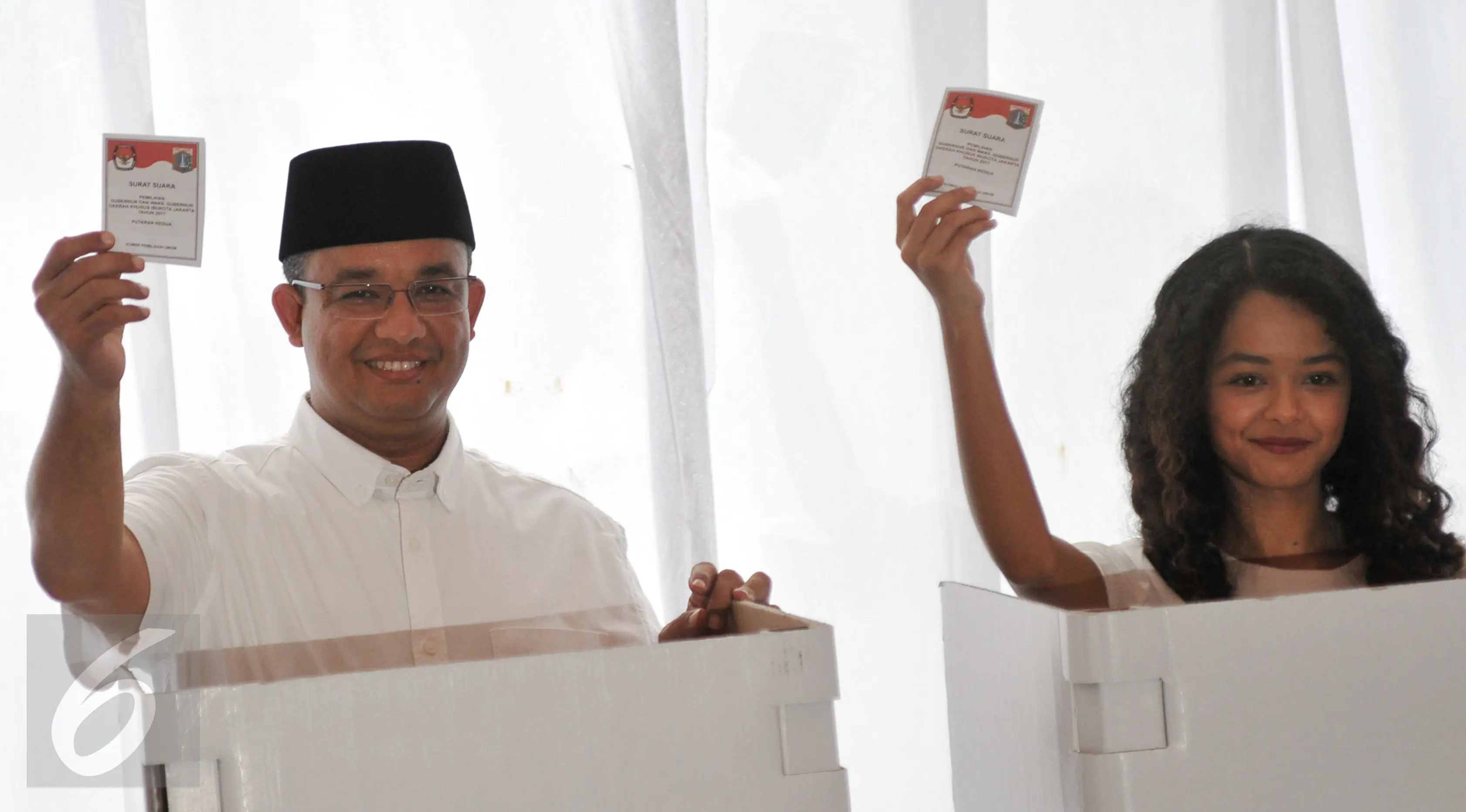 Anies Baswedan bersama anaknya menunjukan kertas suara sebelum memasukan ke kotak saat menggunakan hak pilihnya di TPS 28 Cilandak, Jakarta Selatan, Rabu (19/4). (Liputan6.com/Yoppy Renato)