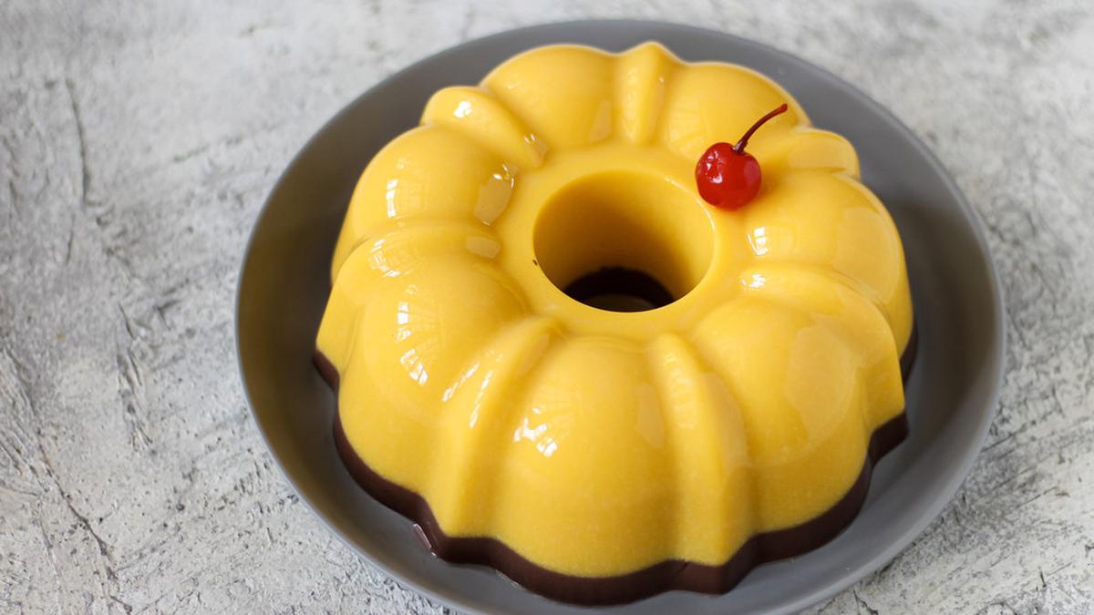 Puding labu kuning yang lembut dan manis, dihias dengan potongan buah segar dan whipped cream