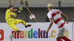 Kiper PSS Sleman, Ega Rizky menghalau tendangan dari bek Madura United, Jaimerson Xavier dalam laga Grup C Piala Menpora 2021 di Stadion Si Jalak Harupat, Bandung, Selasa (23/3/2021). PSS Sleman kalah 1-2 dari Madura United. (Bola.com/M Iqbal Ichsan)