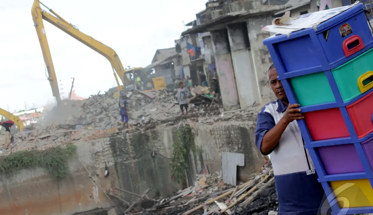 Seorang warga membawa lemari saat penggusuran pemukiman di pinggir Waduk Pluit, Jakarta Utara, Minggu (11/1/2015). (Liputan6.com/Faizal Fanani)