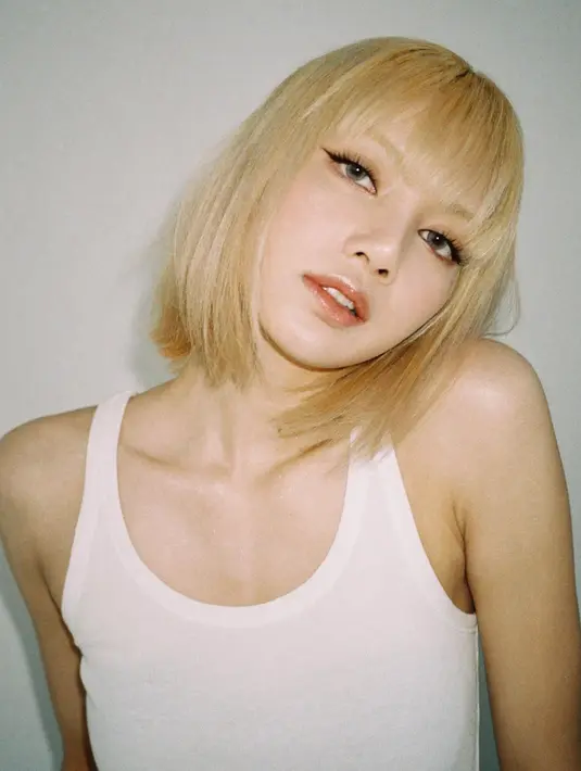 Lisa dengan rambut pendek blondenya saat pemotretan. Personil Blackpink ini tampil simpel menggunakan tanktop berwarna putih. (Instagram/@lalalalisa_m)