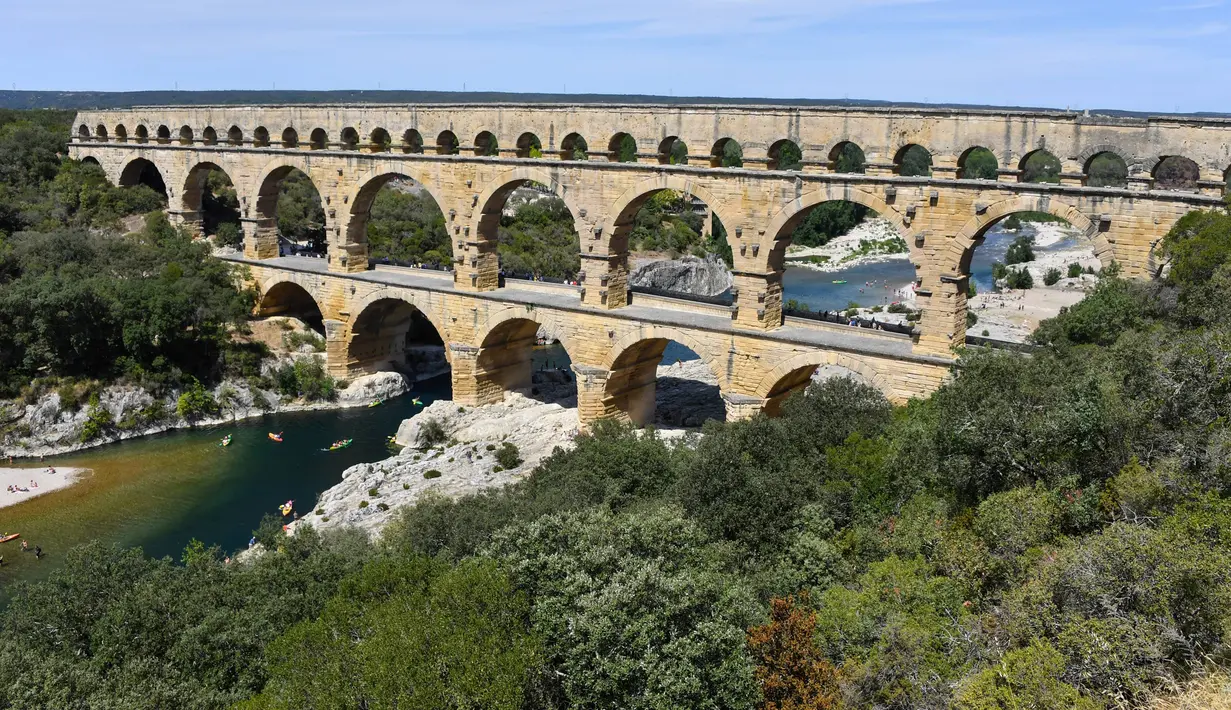 Pemandangan Pont du Gard atau Jembatan Gard di Vers-Pont-du-Gard, Prancis, Rabu (21/8/2019). Karena kemegahannya, jembatan ini mendapat gelar sebagai peninggalan bersejarah dunia oleh UNESCO. (Pascal GUYOT/AFP)