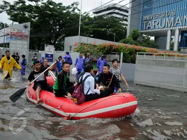 Warga menggunakan perahu karet melintasi banjir yang merendam Jalan S Parman, di depan Universitas Tarumanagara (Untar), Jakarta, Selasa (21/2). Banjir di kawasan ini disebabkan meluapnya beberapa sungai di Jakarta Barat. (Liputan6.com/Gempur M Surya)