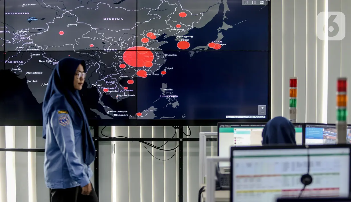 Petugas melewati layar pemantau yang menunjukan penyebaran virus corona (COVID-19) di Dinas Kesehatan DKI Jakarta, Senin (9/3/2020). Dari 3.580 orang yang menghubungi Posko COVID-19 DKI Jakarta, ada 64 kasus kategori Orang Dalam Pantauan dan 56 Pasien Dalam Pengawasan. (Liputan6.com/Faizal Fanani)