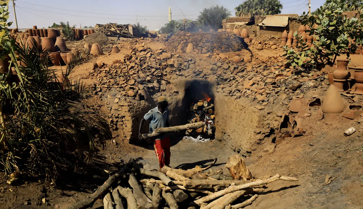 Seorang perajin Sudan membakar tembikar di Khartoum, Sudan (20/10/2020). Para perajin tembikar di Sudan memanfaatkan tanah liat sisa banjir untuk membuat benda-benda kerajinan tersebut. (Xinhua/Mohamed Khidir)