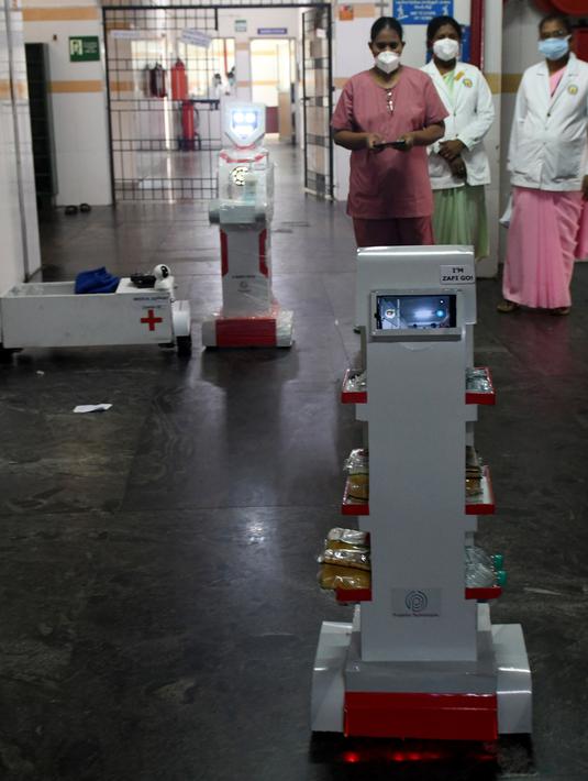 Staf medis berpartisipasi dalam demo robot interaktif 'Zafi' di rumah sakit Stanley Medical di Chennai, 6 April 2020. Rumah sakit ini mengerahkan robot untuk melayani makanan dan obat-obatan bagi pasien Covid-19 dalam upaya meminimalkan tenaga medis tertular virus corona. (Arun SANKAR/AFP)