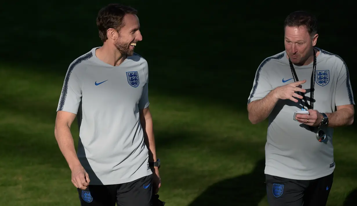 Pelatih Inggris, Gareth Southgate berbincang dengan asistennya Steve Holland saat latihan di Ciudad Deportiva Luis del Sol, Sevilla (14/10). Inggris akan melawan Spanyol  di Liga A Grup 4 UEFA Nations League 2018. (AFP Photo/Jorge Guerrero)