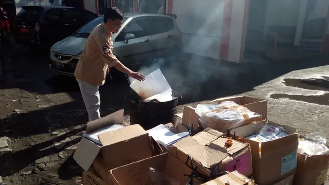 Petugas KPUD Garut tengah menghanguskan puluhan ribu kertas surat suara yang tidak digunakan dalam pemilu