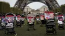 Kereta bayi kosong beserta 30 foto anak-anak dan remaja yang masih hilang atau diculik dalam serangan Hamas ke Israel pada 7 Oktober dipajang dalam aksi solidaritas perwakilan organisasi Yahudi di dekat Menara Eiffel di Paris, Kamis (26/10/2023). (AP Photo/Themba Hadebe)