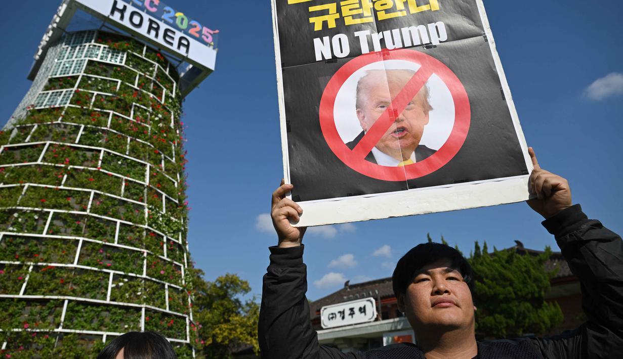 Seorang pengunjuk rasa Korea Selatan memegang plakat saat unjuk rasa mengecam tekanan Presiden AS Donald Trump untuk meningkatkan investasi Korea Selatan di AS, di Gyeongju pada 29 Oktober 2025, menjelang KTT Kerja Sama Ekonomi Asia-Pasifik (APEC). (Jung Yeon-je/AFP)