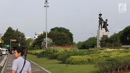 Warga melintasi di kawasan Taman Tugu Tani, Jakarta, Rabu (9/1). Lima taman yang akan direvitalisasi Pemprov DKI pada tahun ini adalah Taman Tebet, Taman Puring, Taman Tugu Tani, Taman Mataram, dan Taman Langsat. (Liputan6.com/Helmi Fithriansyah)