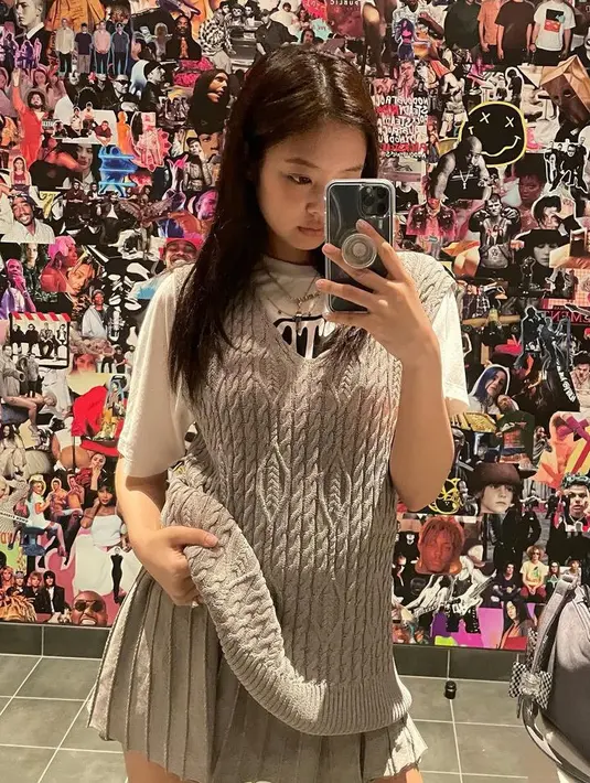 Jennie Blackpink tampil mengenakan vest abu-abu knitwear yang serasi dengan mini skirt pleated serta dipadukan inner tshirt putih. Gayanya cocok untuk hangout bersama teman-teman. [@jennierubyjane]