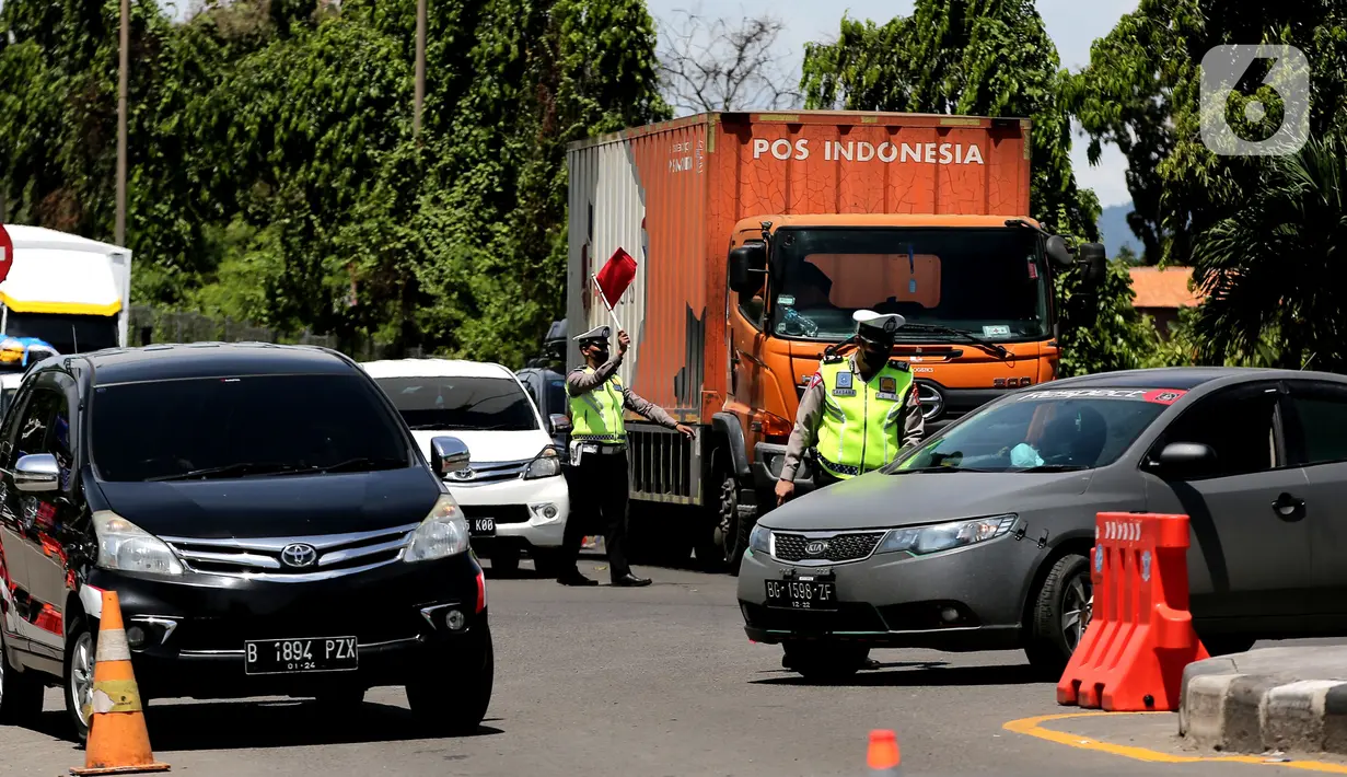 <p>Polisi mengatur lalu lintas saat melakukan sistem buka tutup jalan menuju Pelabuhan Merak, Cilegon, Banten, Jumat (29/4/2022). Sistem buka tutup tersebut membuat kemacetan panjang hingga ke dalam Tol Tangerang-Merak. (Liputan6.com/Angga Yuniar)</p>