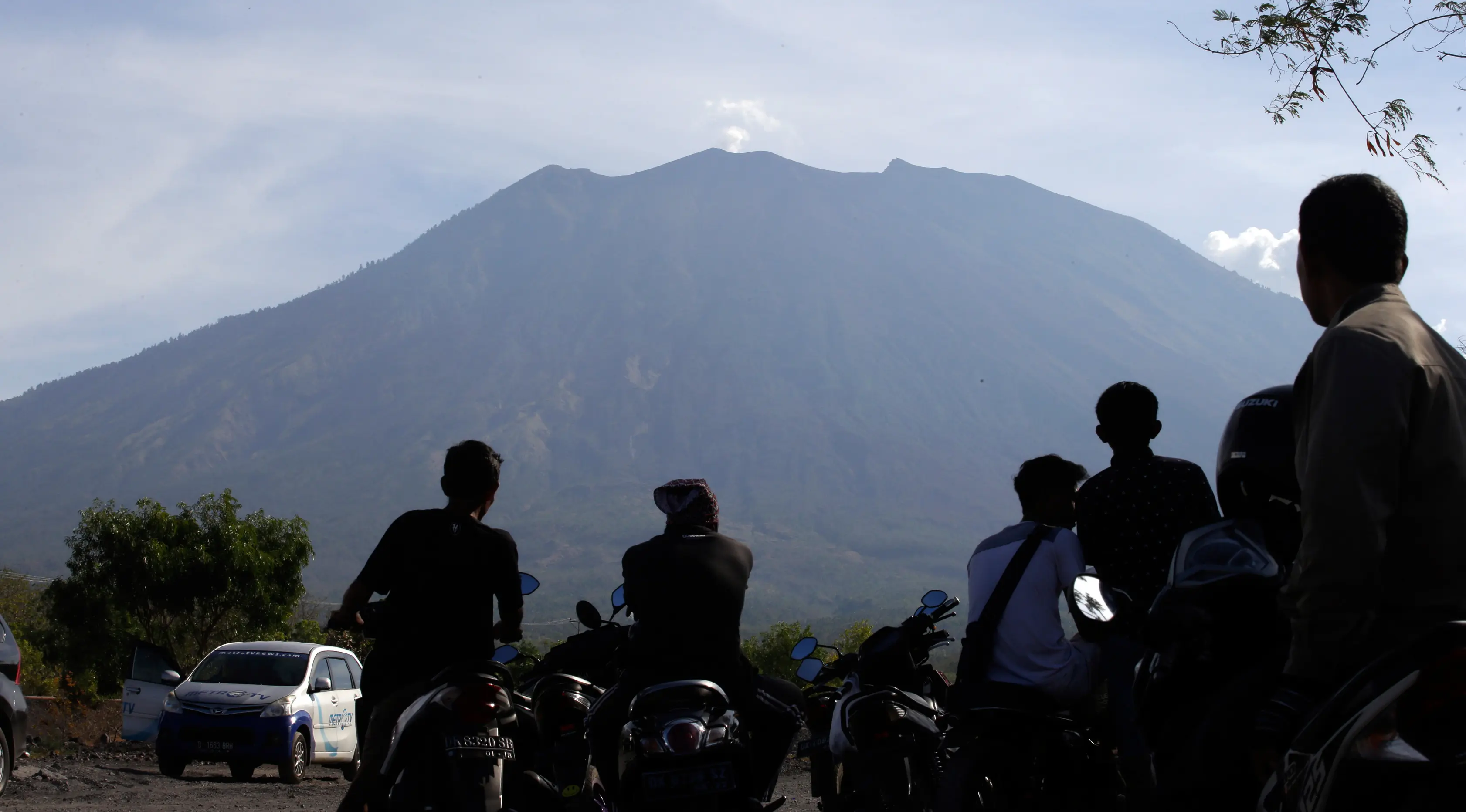 Penduduk mengamati Gunung Agung dari Desa Kubu, Kabupaten Karangasem, Bali, Rabu (11/10). Menurut BNPB, aktivitas vulkanik Gunung Agung masih tinggi sehingga PVMBG masih menetapkan status awas sejak 22 September lalu hingga saat ini. (AP/Firdia Lisnawati)