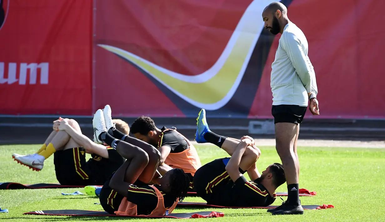 Asisten pelatih Belgia Thierry Henry (kanan) melihat para pemainnya berlatih selama sesi pelatihan tim di Stadion Guchkovo di Dedovsk, Moskow, (8/7). Belgia akan bertanding pada semifinal Piala Dunia 2018 melawan Prancis. (AFP Photo/Franck Fife)